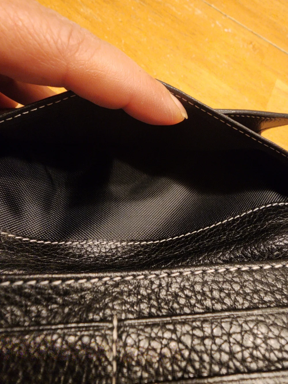 black Christian Dior pebbled leather trifold long wallet featuring gold-tone 